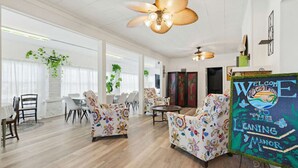Un vaste espace de vie doté d’un haut plafond, d’un ventilateur de plafond et d’un panneau mural.
