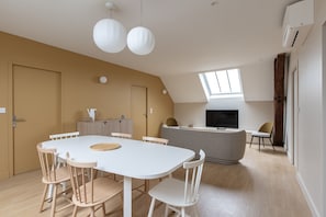 Una cocina moderna con comedor, sofá y televisor.