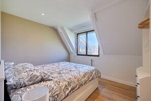 Un dormitorio con cama, ventana y radiador.