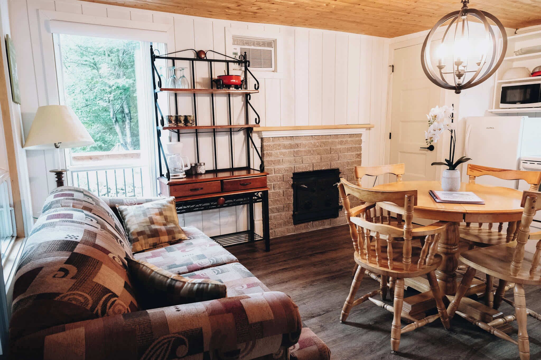 Un salon chaleureux avec une cheminée, des meubles en bois et un coin repas.