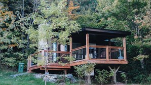 A wooden cabin with a balcony, surrounded by trees. - Nature Escape and Miller Zoo | Buddy Shack (Frampton)