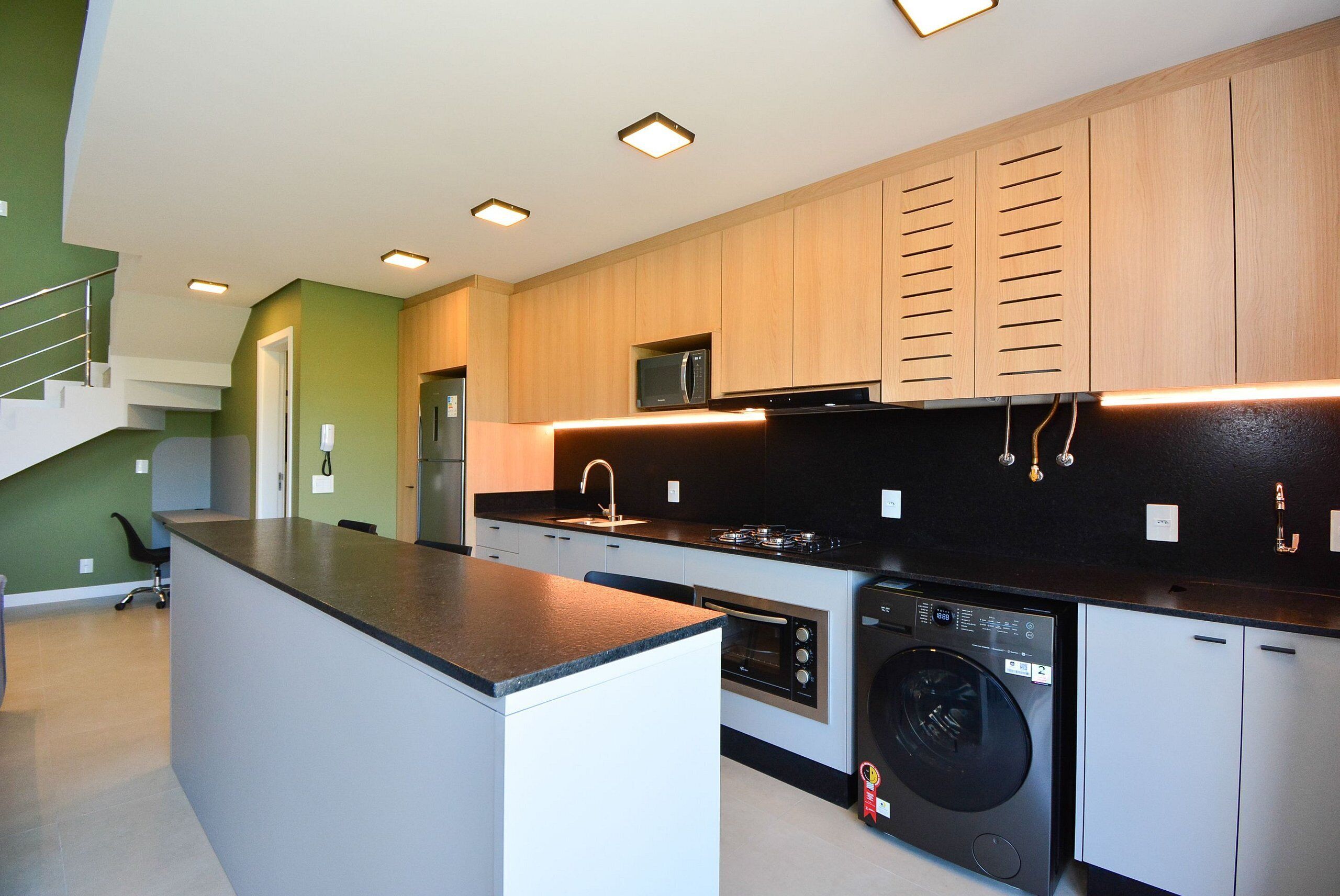 A modern kitchen with built-in appliances, wooden cabinets, and a central island.