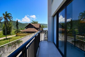 A balcony with a view of a house and mountains. - Moderno Loft na Lagoa da Conceição  (Florianópolis)