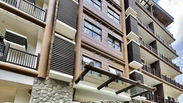 A multi-story building with a stone facade and the name 'BRENTHALL' in gold letters. - Cozy Studio Room with Fitness Gym (Baguio)
