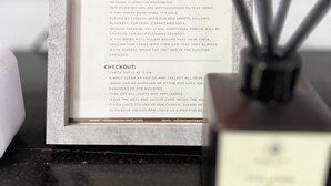 A framed welcome sign with house rules and checkout instructions. - Cozy Studio Room with Fitness Gym (Baguio)