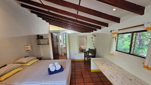 A room with a bed, a bench, a window with curtains, and a tiled floor. - Vrbo Property (Parrita)