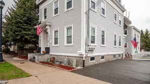 A two-story building with a stone foundation, white siding, and multiple windows.