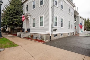 A two-story building with a stone foundation, white siding, and multiple windows.