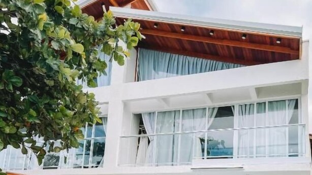 A two-story building with a swimming pool, large windows, and a balcony. - Casa cancun hotel boutique e eventos (Penha)