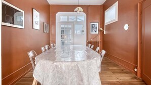 Un salón de conferencias con una mesa grande, sillas y una puerta que da a otra habitación.