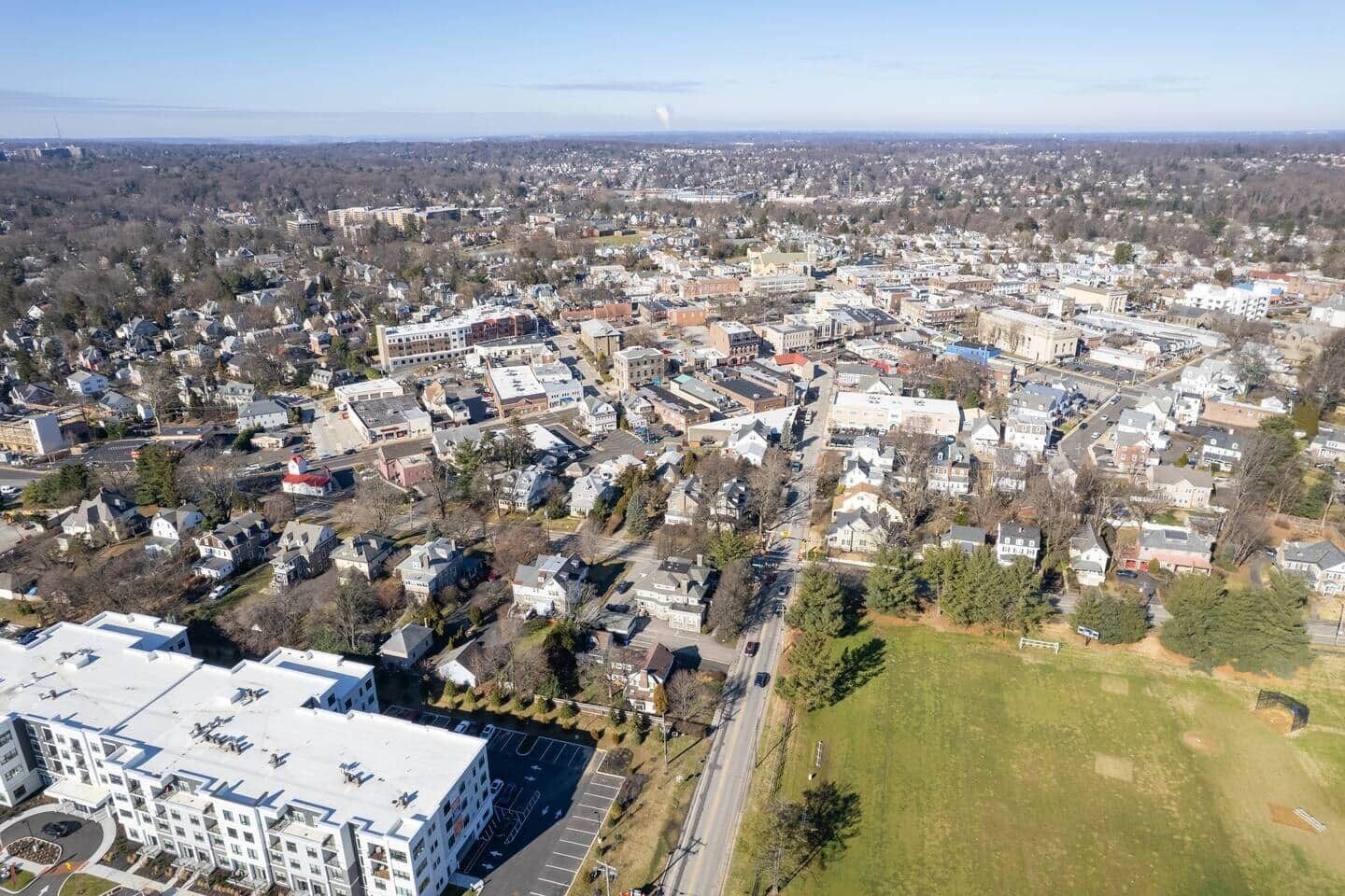 Luchtbeeld van een dichtbevolkt stedelijk gebied met verschillende gebouwen, wegen en groenstroken.