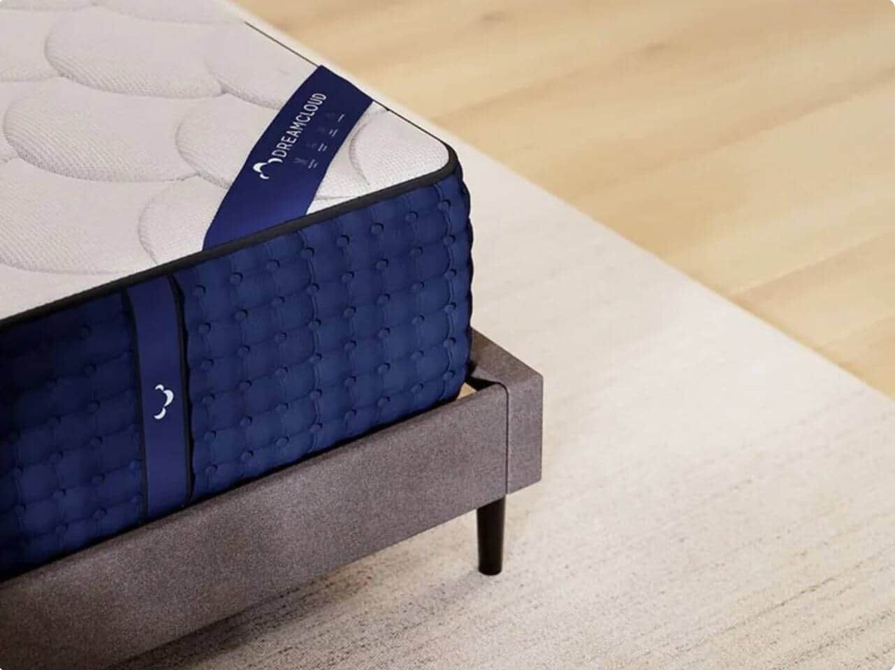 Ein Bett mit einer Matratze mit dem Aufdruck 'DreamCloud' und einem grauen Metallgestell.