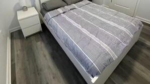 A bedroom with a bed, nightstand, and a door. - 2-bedroom apartment in excellent Newburgh with AC and charm (Newburgh)