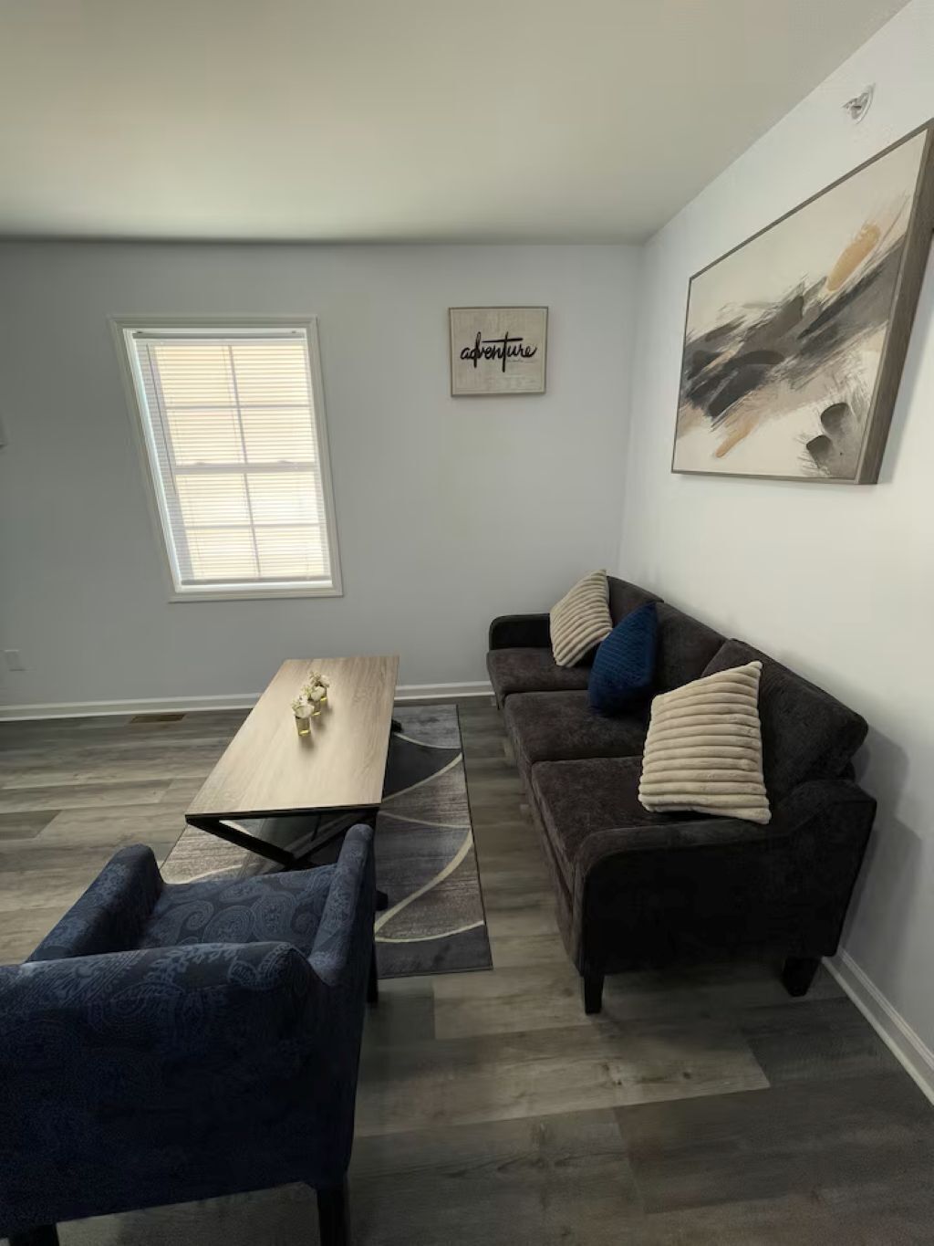 A modern living room with a sofa, a coffee table, and a rug.