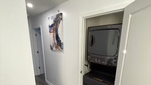 A hallway with a modern kitchen area, including a microwave and oven, and a door leading to another room. - 2-bedroom apartment in excellent Newburgh with AC and charm (Newburgh)