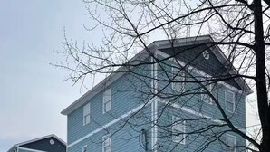 A multi-story residential building with a covered parking area. - 2-bedroom apartment in excellent Newburgh with AC and charm (Newburgh)