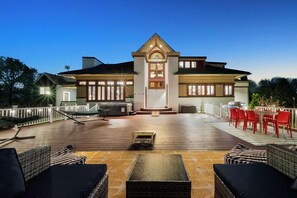 A large house with a deck, outdoor seating, and a grill area. - Wayfinder House | Game Room • Hot Tub • Movie Room (Canandaigua)