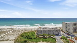 A coastal hotel with a beach view, multiple floors, and a parking area. - "Heaven on Top" – 15th-Floor Gulf Views, Pool & Hot Tub , Steps to Beach (Pensacola Beach)