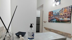 A bathroom with a marble sink, a bottle of hand sanitizer, a black bowl, and a decorative item. - Bosuites Rome (Rome)