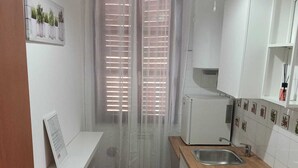 A compact kitchen with a wooden countertop, a sink, and white cabinets. - Vibes Pigneto, central location near metro C stop suitable for families (Roma)