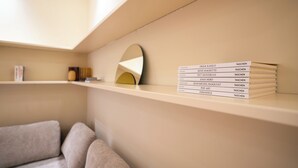 Ein modernes Interieur mit einer Bücherwand, einem Sofa und einem wandmontierten Spiegel.