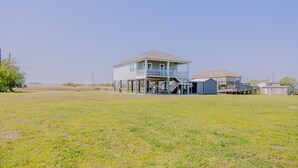 A two-story house with a balcony and a covered porch area. - Intracoastal Sanctuary 2BR 2BA in Sabine Pass (Sabine Pass)