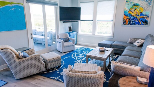 A modern living room with a large TV, comfortable seating, and a view to the outside. - Intracoastal Sanctuary 2BR 2BA in Sabine Pass (Sabine Pass)