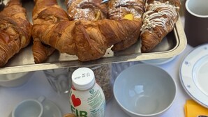 A tray of assorted pastries, a bottle of milk, and wooden coasters on a table. - Antico Casale San Lorenzo (Toscana)