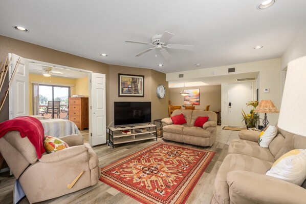 A living room with a sofa, TV, and a red patterned rug. - CASA MIDDIE-Two Bedroom with the best View (Phoenix, Arizona)