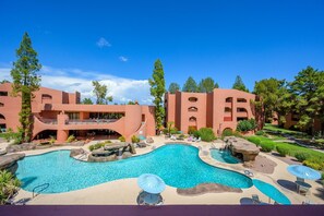 A resort with a large pool, outdoor seating, and a distinctive pink building. - CASA MIDDIE-Two Bedroom with the best View (Phoenix, Arizona)