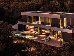 A modern two-story house with a swimming pool, outdoor seating, and a large glass facade. - Heated Pool, Atreeum and Olive Groove - Villa M Excelsior (Sveti Donat)
