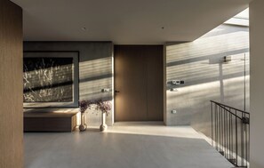 A modern interior with a large abstract painting, a wooden door, and a minimalist staircase. - Heated Pool, Atreeum and Olive Groove - Villa M Excelsior (Sveti Donat)