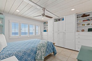 A bedroom with a bed, a ceiling fan, white cabinets, and a window with blinds. - Pinnacle Port, Unit C3-601 (Panama City Beach)