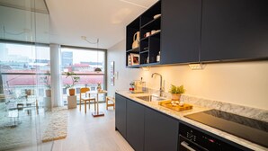 Eine moderne Küche mit dunklen Schränken, einer Marmorarbeitsplatte und einem eingebauten Backofen.