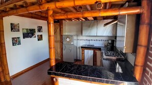 A kitchen with a gas stove, refrigerator, and a wooden counter. - Cozy Lodging in the coffee growing region (Ulloa)