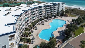 Un hotel con varios balcones, piscina y vistas a la playa.