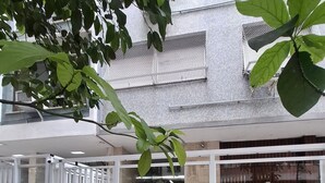 Ein Gebäude mit einem gefliesten Innenhof, einem befestigten Eingang und einer Treppe, die zu einer oberen Ebene führt.