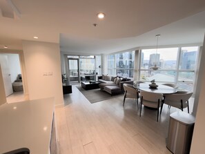A modern living room with a sofa, coffee table, and dining area.