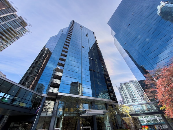 A high-rise building with a modern glass facade, surrounded by other tall structures.