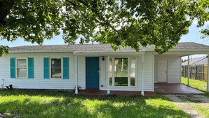 A single-story house with a front door, a covered porch, and a small front yard. - 3-bedroom house in amazing Orlando with AC and fitness room-BEACH STYLE BUNGALOW (Orlando)