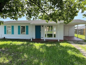 A single-story house with a front door, a covered porch, and a small front yard. - 3-bedroom house in amazing Orlando with AC and fitness room-BEACH STYLE BUNGALOW (Orlando)