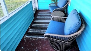A porch with a blue exterior, wicker furniture, and a view of the backyard. - 3-bedroom house in amazing Orlando with AC and fitness room-BEACH STYLE BUNGALOW (Orlando)