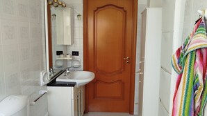 Un baño con inodoro, bidé, lavabo y espejo.