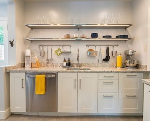 A modern kitchen with stainless steel appliances, white cabinetry, and glassware on shelves. - AvonWood: Private Yard, Stocked Kitchen, Great Porches (Birmingham)