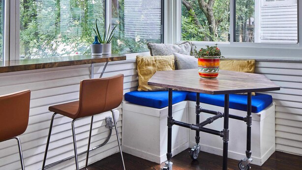 Ein Eckzimmer mit Fensterbank, Tisch und Stühlen.