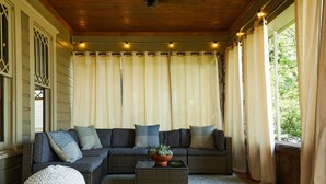 Ein gemütliches Wohnzimmer mit einer Eckcouch, einem runden Pouf und einem Couchtisch mit einer Pflanze.