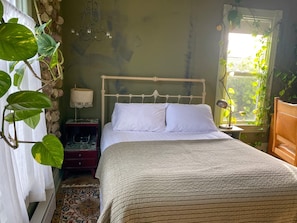 Un lit avec une tête de lit blanche, une lampe de chevet et une table de chevet avec une lampe.