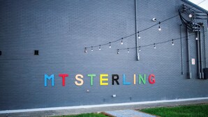 Un bâtiment avec un mur en briques grises et le nom « MTSTERLING » écrit en lettres colorées.