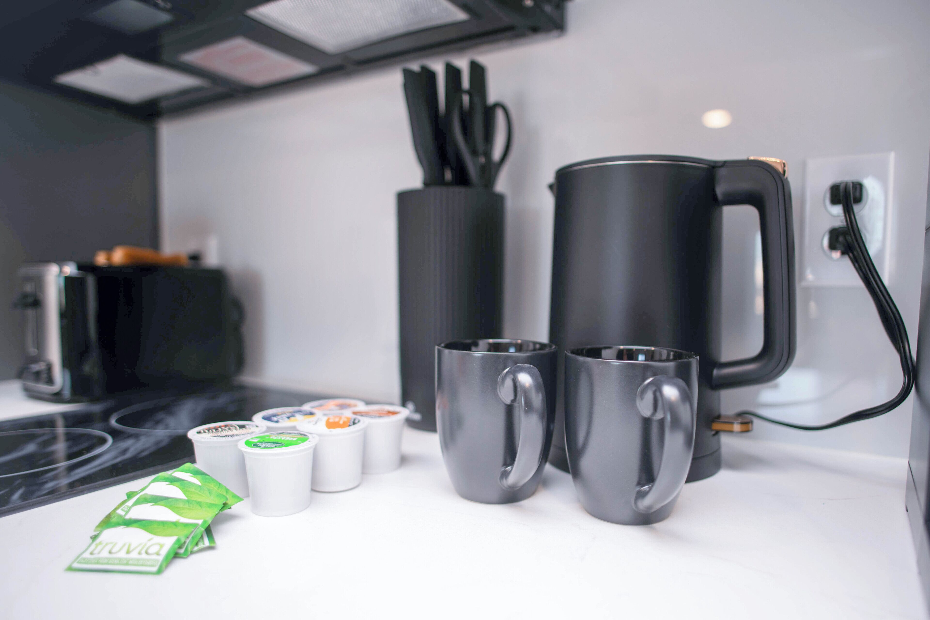 Angolo cottura con macchina del caffè, tazze e bustine di tè.