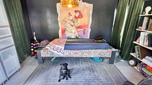 A room with a bed, a dog, a bookshelf, and a wall with a painting. - Luxe in Lampasas 1920's home, pool, hot tub, private cabana with massage chair. (Lampasas)
